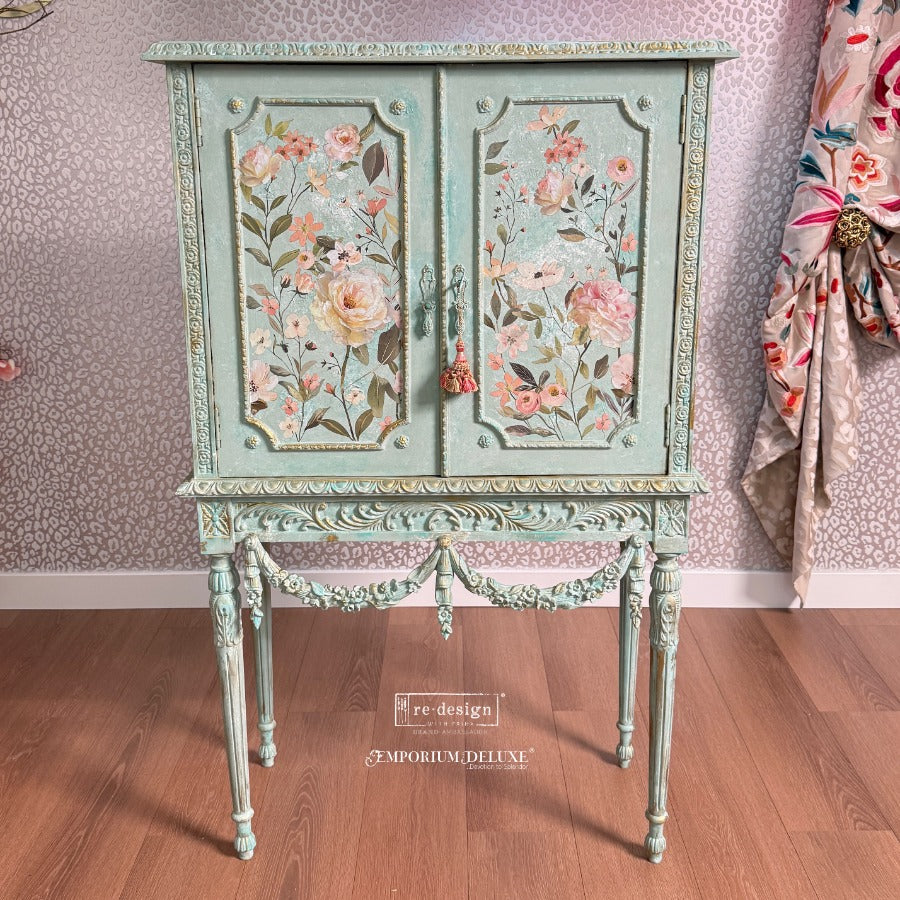 Soft, romantic, and effortlessly graceful, Blush Harmony is a dreamy floral transfer designed to bring lightness and elegance to any surface. Featuring delicate blooms in gentle shades of blush pink, ivory, and soft greenery, this design captures the beauty of freshly gathered garden florals in full, airy composition. on the front of an aqua colored small ornate cabinet