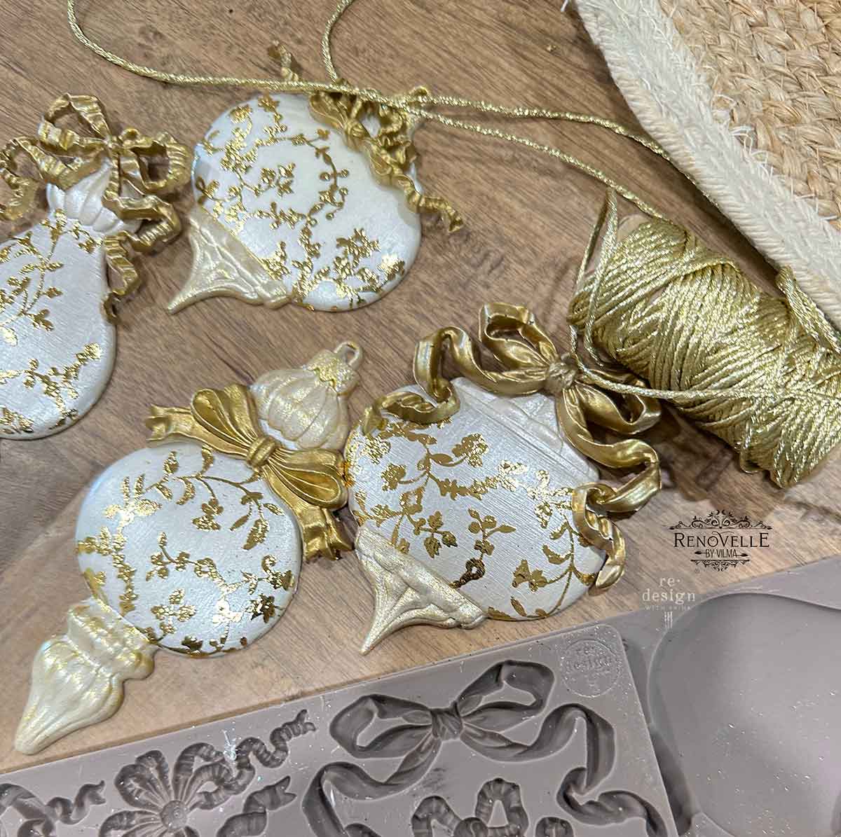 Decorative Christmas ornaments with gold accents on a wooden surface, featuring Renovelle branding.