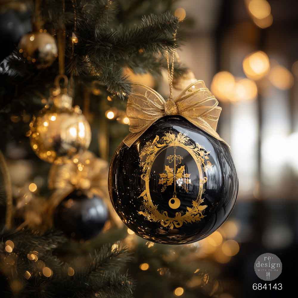 Decorative Christmas ornament with gold design on a tree with blurred lights in the background