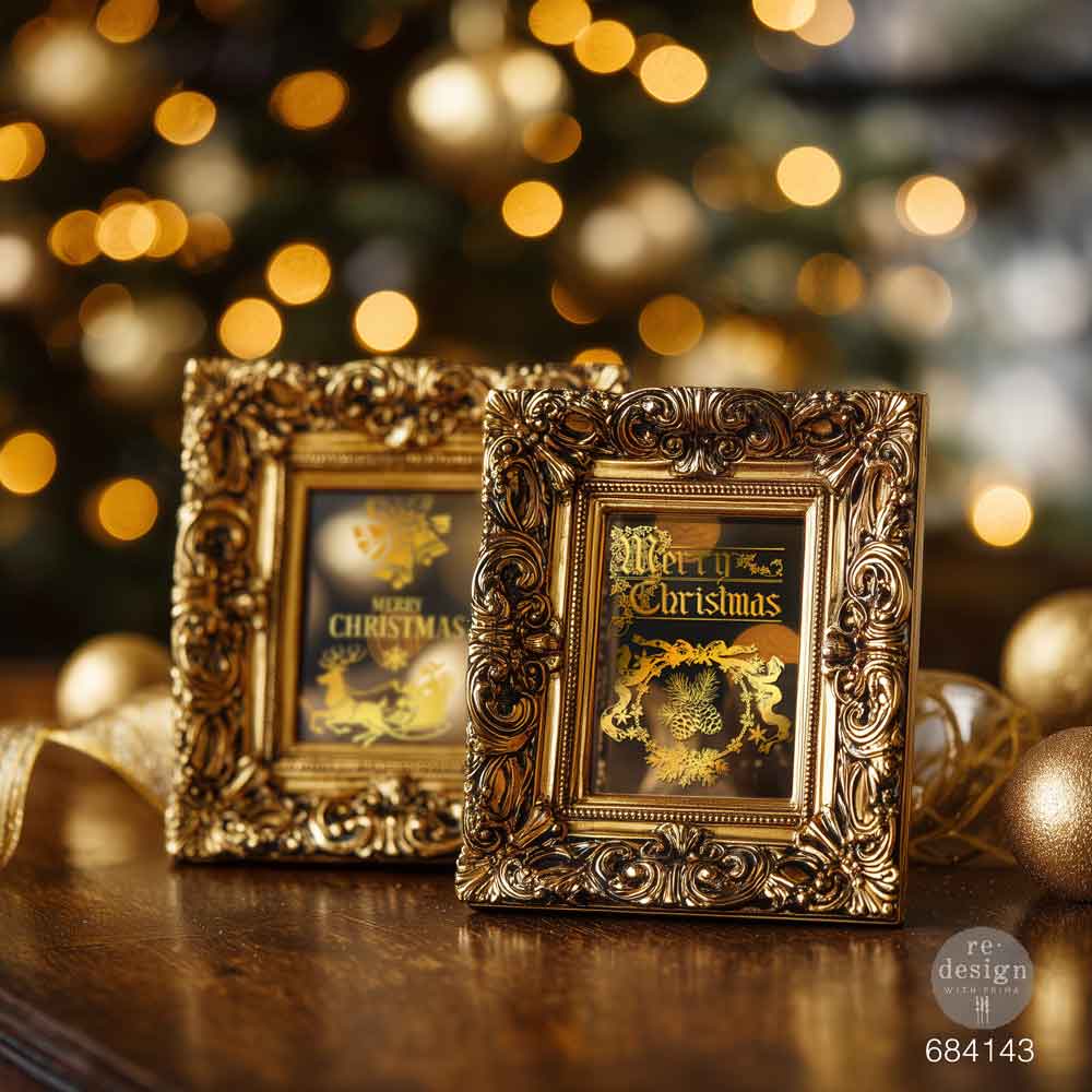 Two ornate gold frames with Christmas-themed pictures on a wooden surface with a blurred festive background.