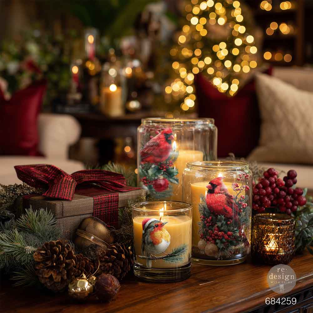 Decorative candles with festive designs on a table in a cozy living room setting.