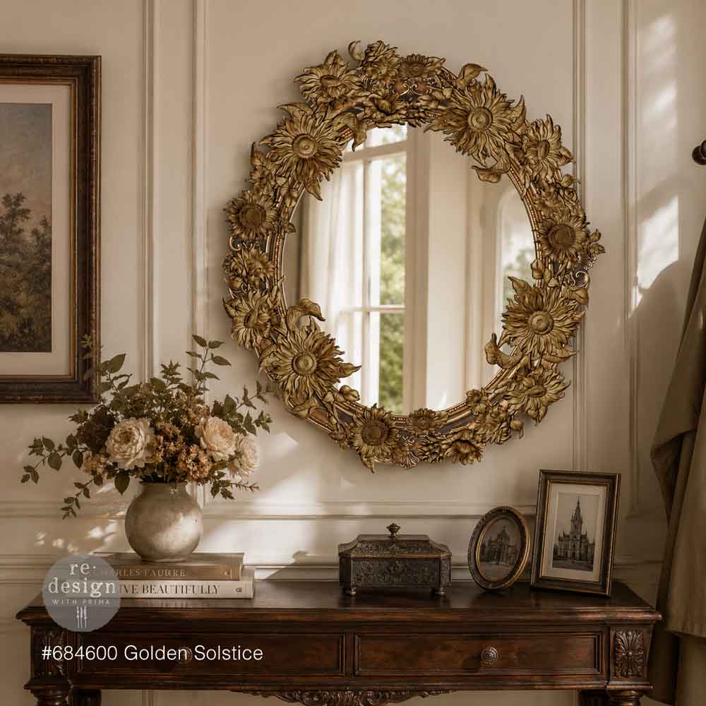 Decorative gold mirror on a wall with a wooden console table below featuring books, a vase, and framed pictures.