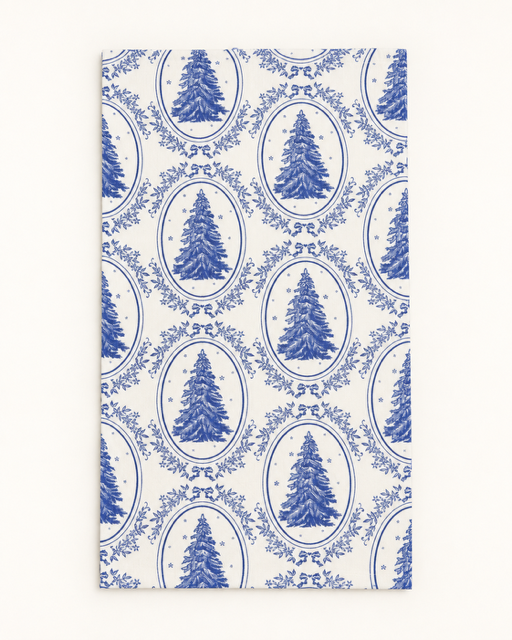 A rectangular white paper napkin or placemat featuring a classic blue toile pattern with Christmas trees inside ovals.