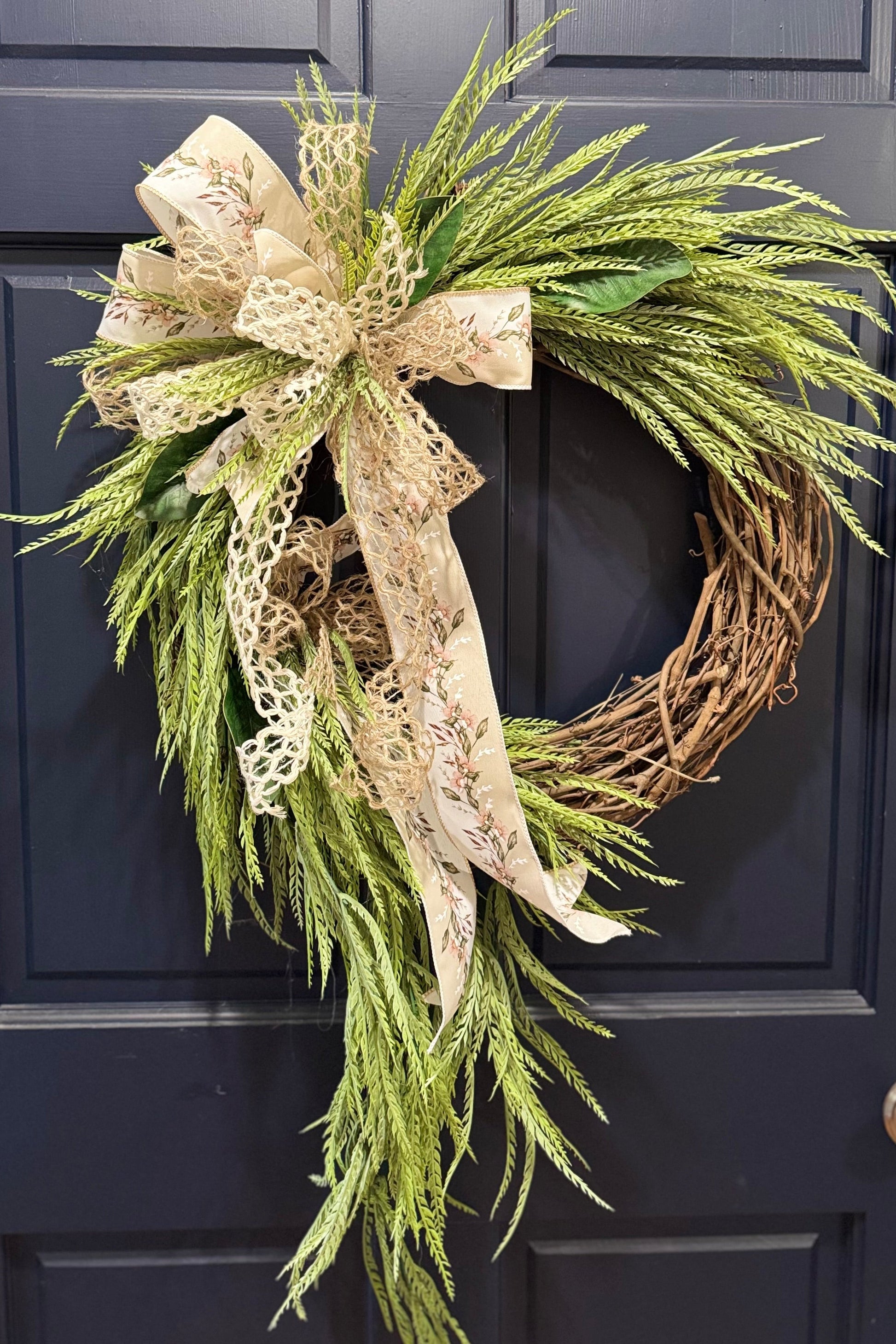 wreath hanging on a door with the saw grass in it as the focal point.