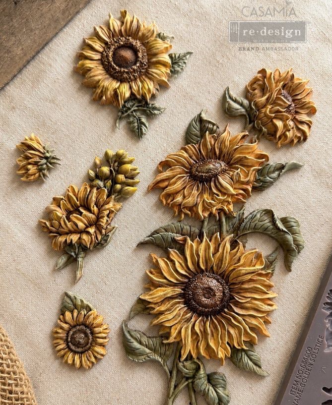 Decorative sunflower designs on a textured surface with 'Casamia' branding.