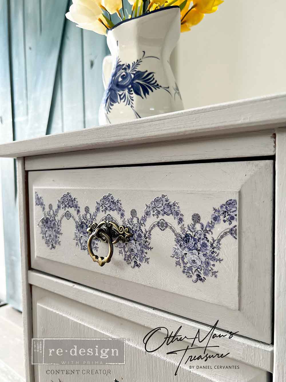 Decorative dresser with floral design and a vase of flowers on top