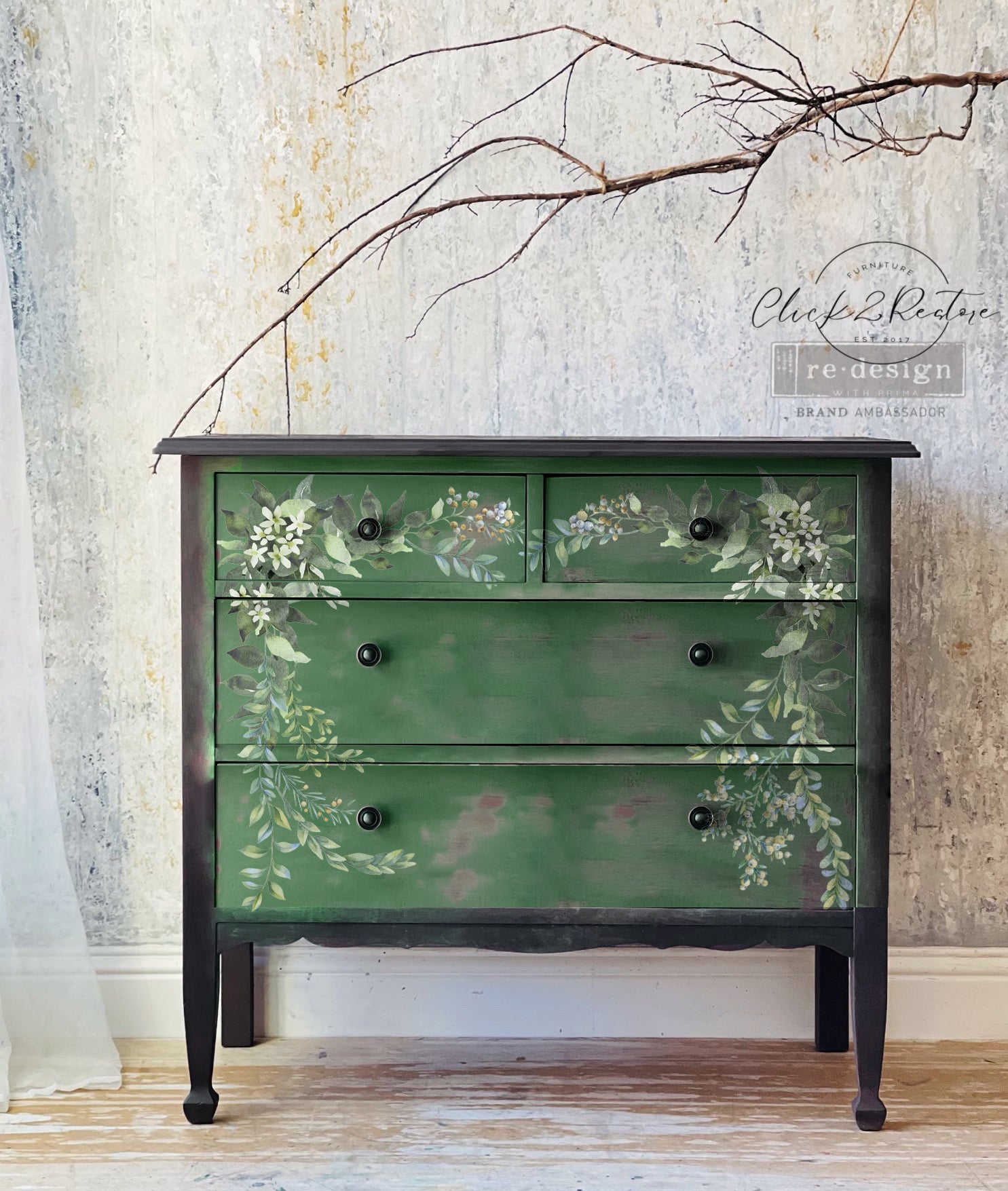 Green dresser with floral patterns against a textured wall.