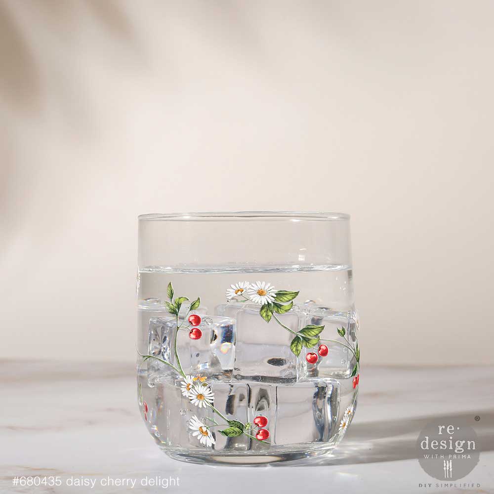 Clear glass tumbler with floral design on a light background