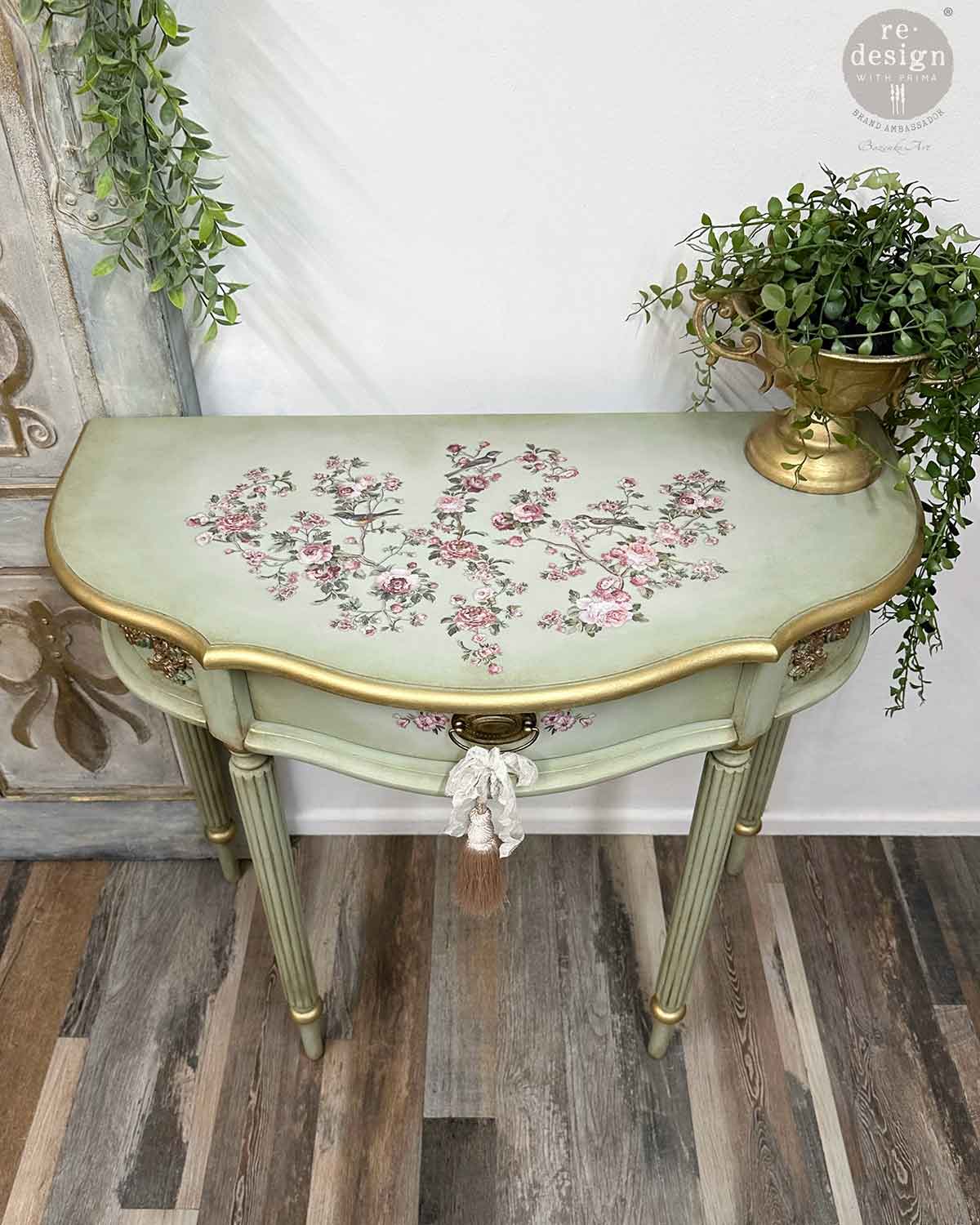 Decorative table with floral patterns and gold accents on a wooden floor.