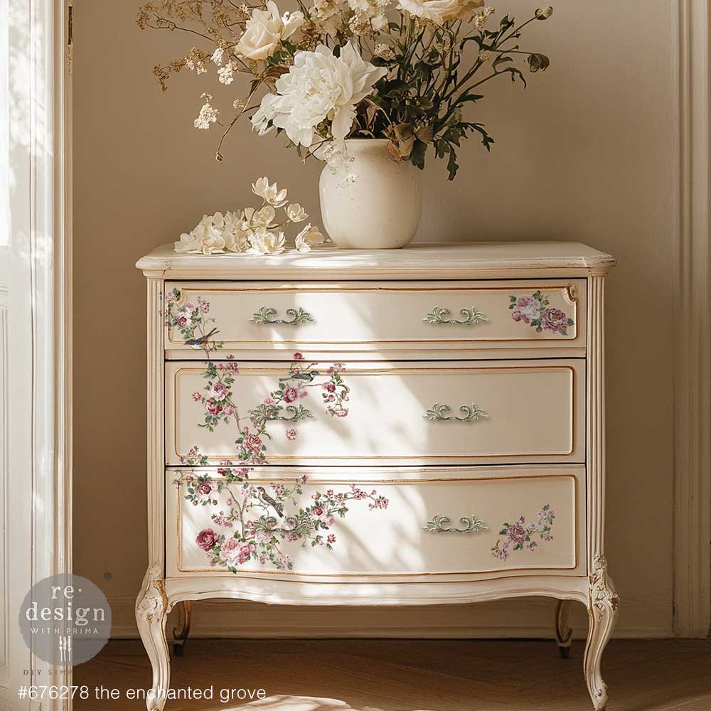 Decorative chest of drawers with floral patterns and a vase of flowers on top against a beige wall.