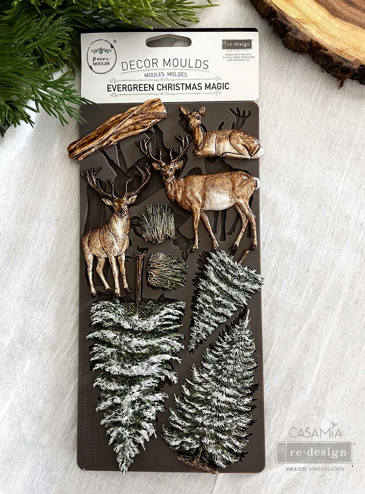 From tall pine trees to graceful deer, the Evergreen Christmas Magic Décor Mould® is filled with winter forest charm. Use these classic holiday elements to build woodland scenes, embellish frames and trays, or add natural elegance to your Christmas crafts. The textures and shapes make this mould a go-to for rustic, traditional, and enchanted winter projects alike.

Crafted from high-quality silicone, it’s food-safe and perfect for use with modeling materials, resin, wax, or even chocolate.
Only by Redesign 