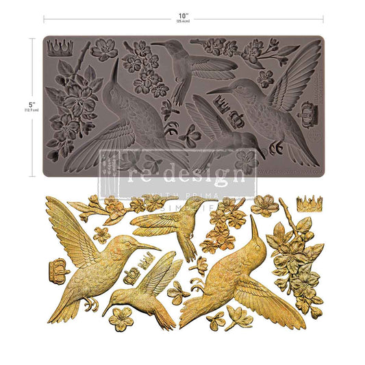 grey silicone mould of humming birds and cherry blossoms with the castings next to the mould