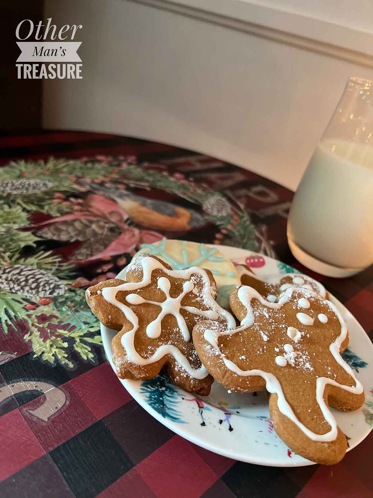 Decorative gingerbread cookies on a plate with a candle in the background