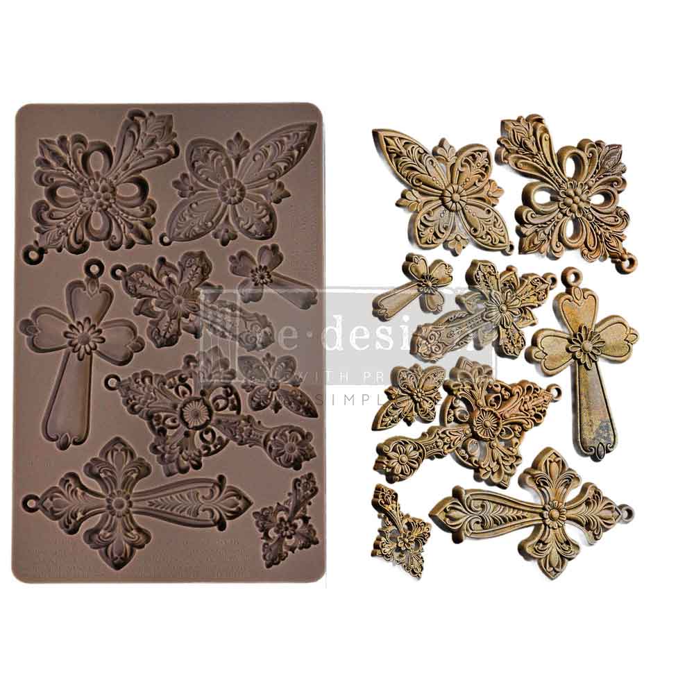 Decorative metal mold with intricate designs and corresponding metal embellishments on a white background.