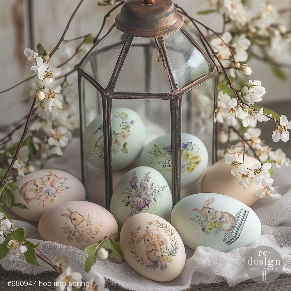 Decorative Easter eggs with floral and animal designs in a lantern surrounded by white flowers.