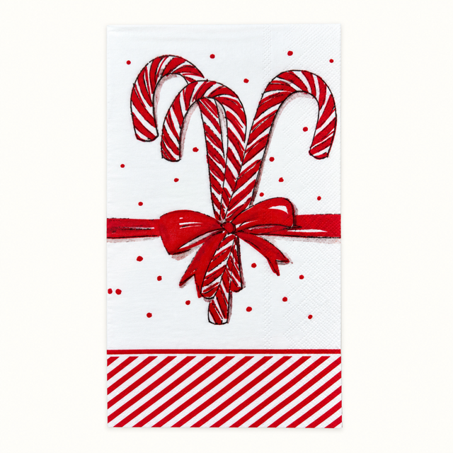 A festive white paper napkin featuring a red and white striped candy cane design, a red ribbon bow, red polka dots, and a red-and-white striped border at the bottom.