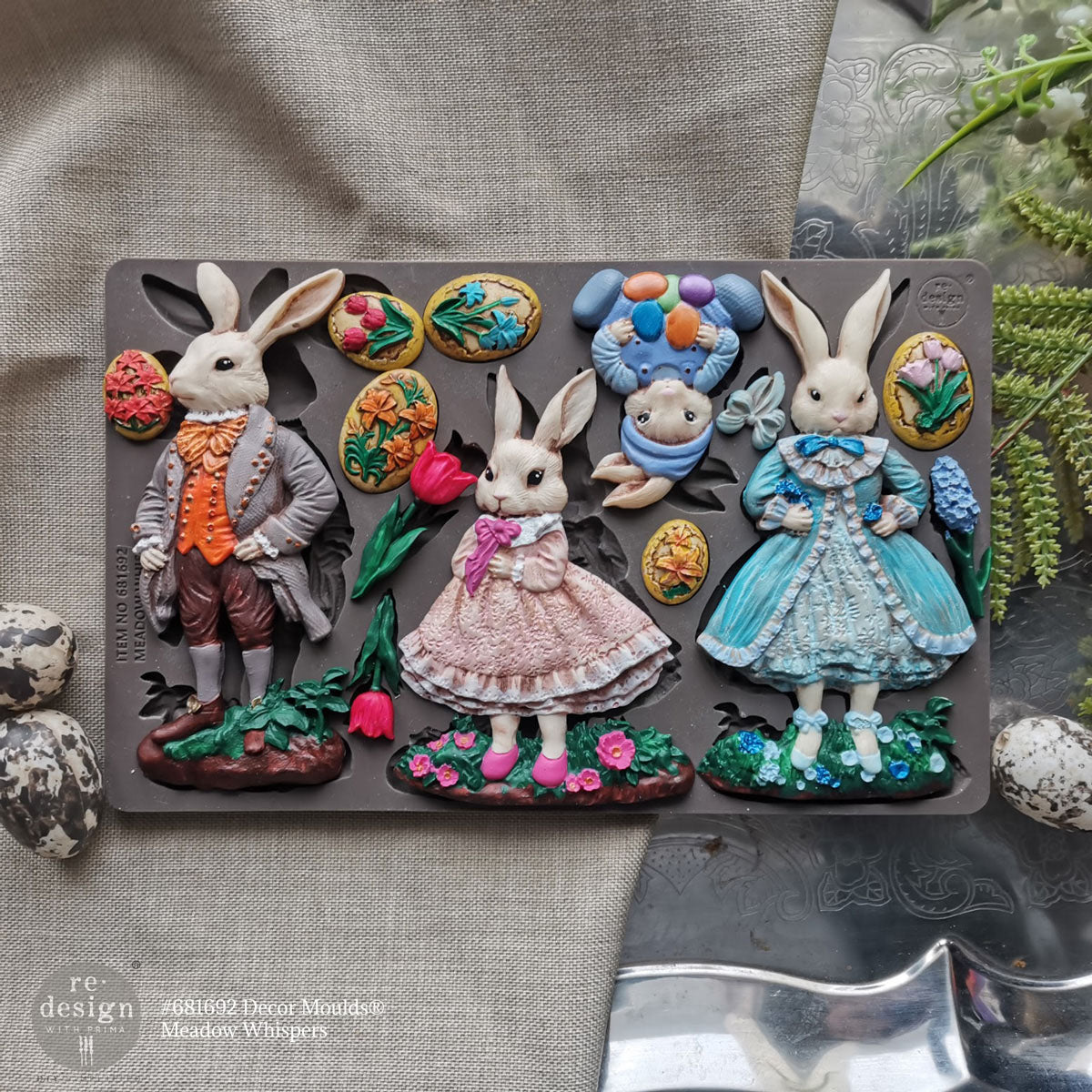 Decorative mold with rabbit figures and floral elements on a textured surface.