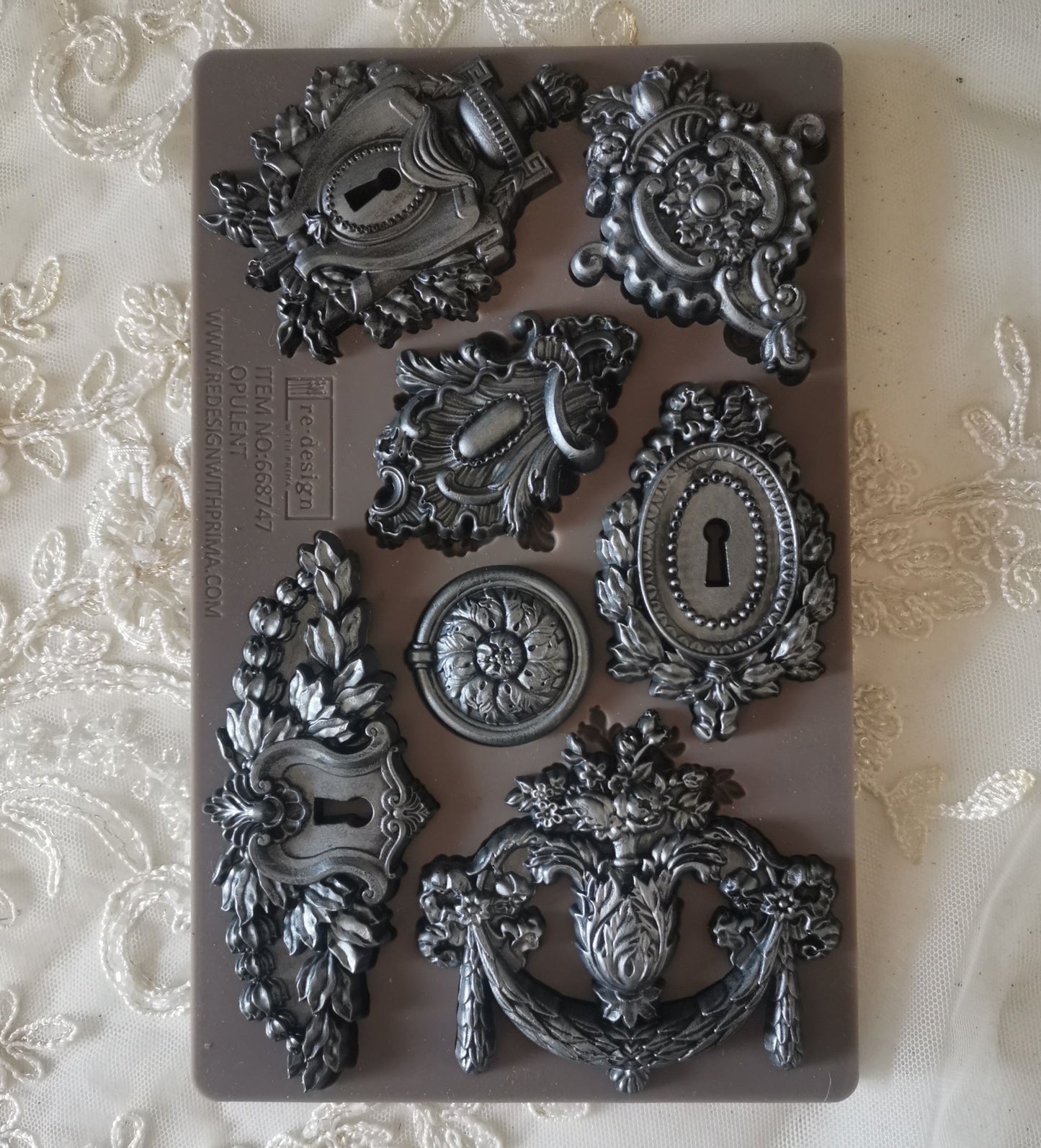 Decorative metal door hardware molds on a textured surface