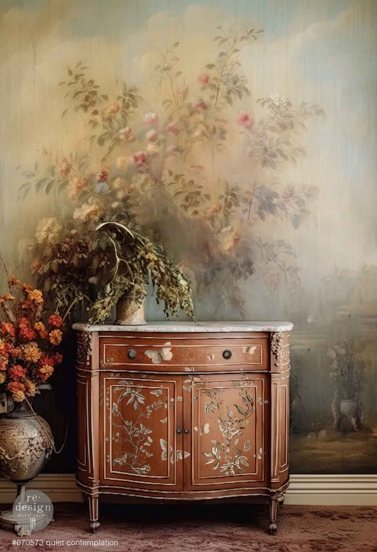 Decorative wooden cabinet with floral design against a wall with floral wallpaper