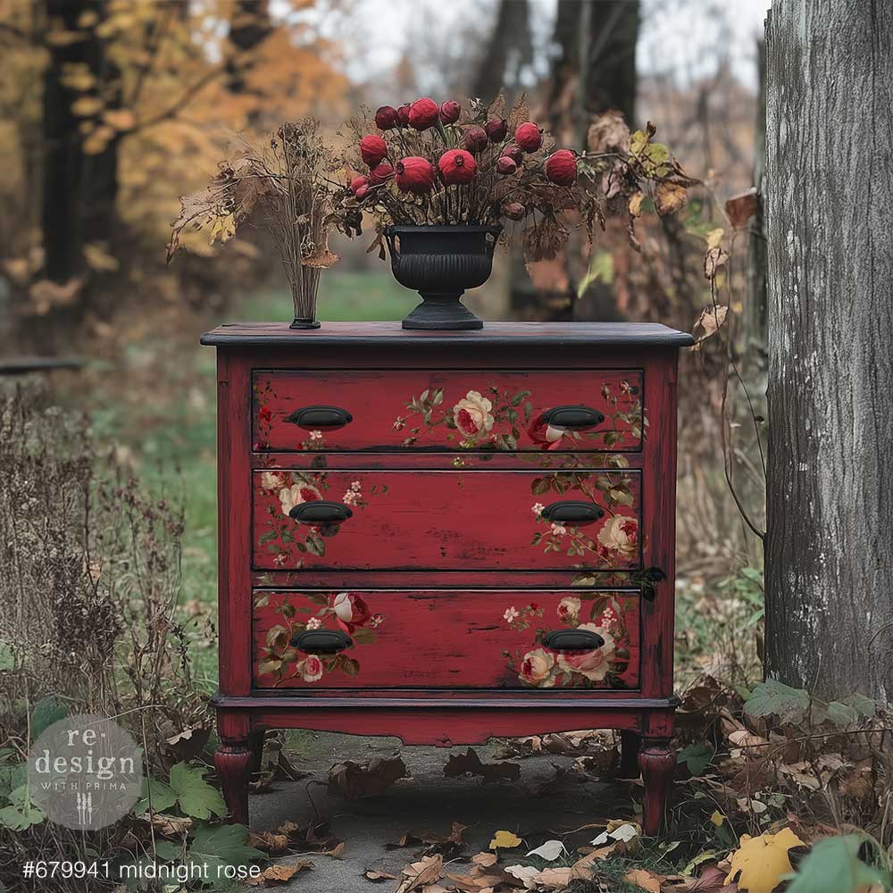 picture of a maroon 3 drawer dresser with the rose transfer on the drawer fronts