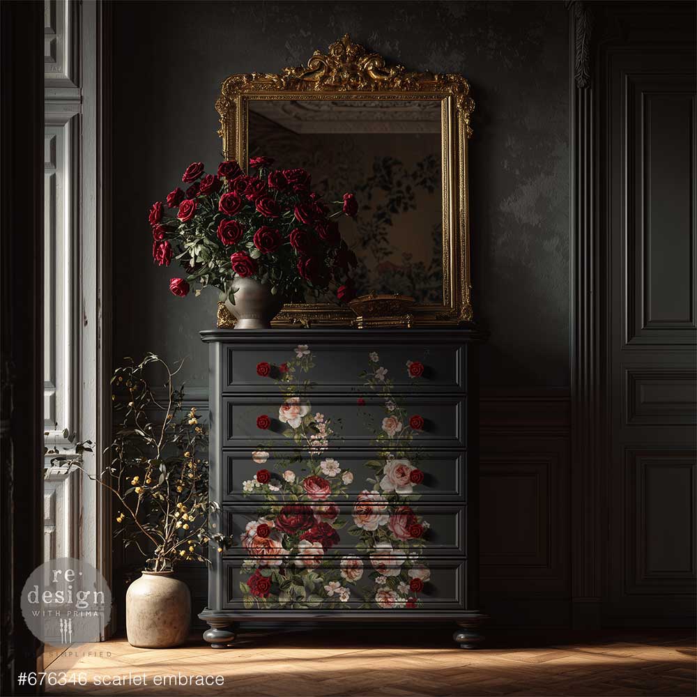 Rich, romantic, and undeniably captivating, Scarlet Embrace features a lush arrangement of blooming roses in deep crimson, soft blush, and warm ivory tones. With its graceful composition and painterly detail, this design evokes timeless elegance—perfect for adding a bold yet refined floral statement to any piece. transfer on a tall grey dresser with a floral vase and mirror on the top